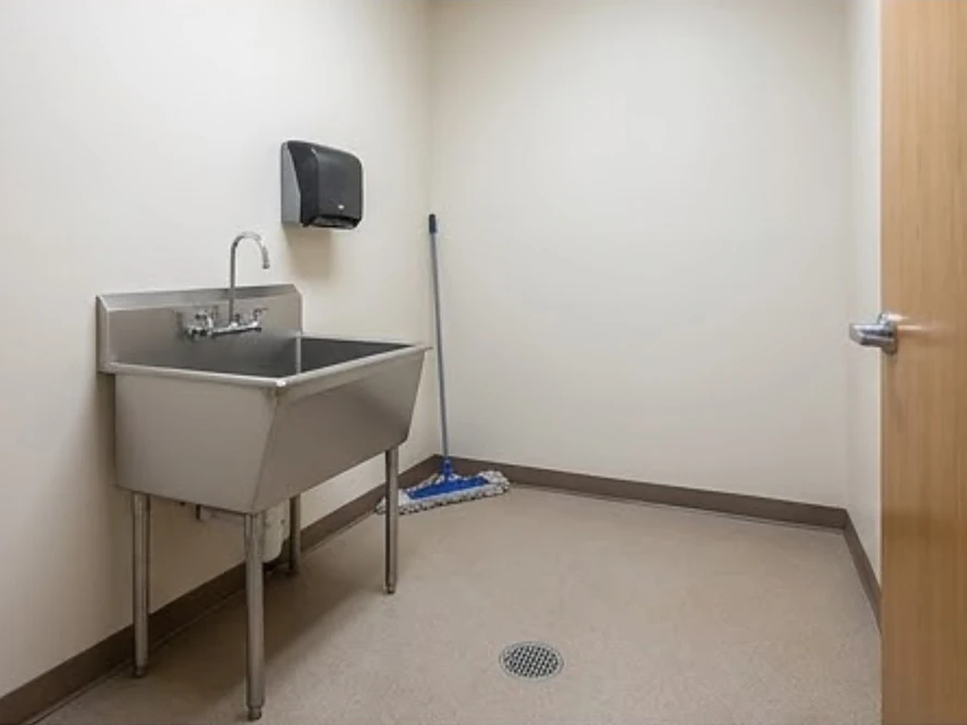 Mop sink and floor drain in a janitor closet, newer