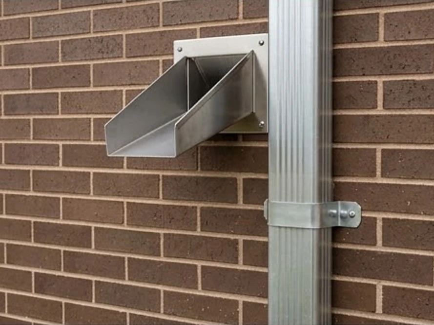 Scupper and downspout on a brick wall, good condition
