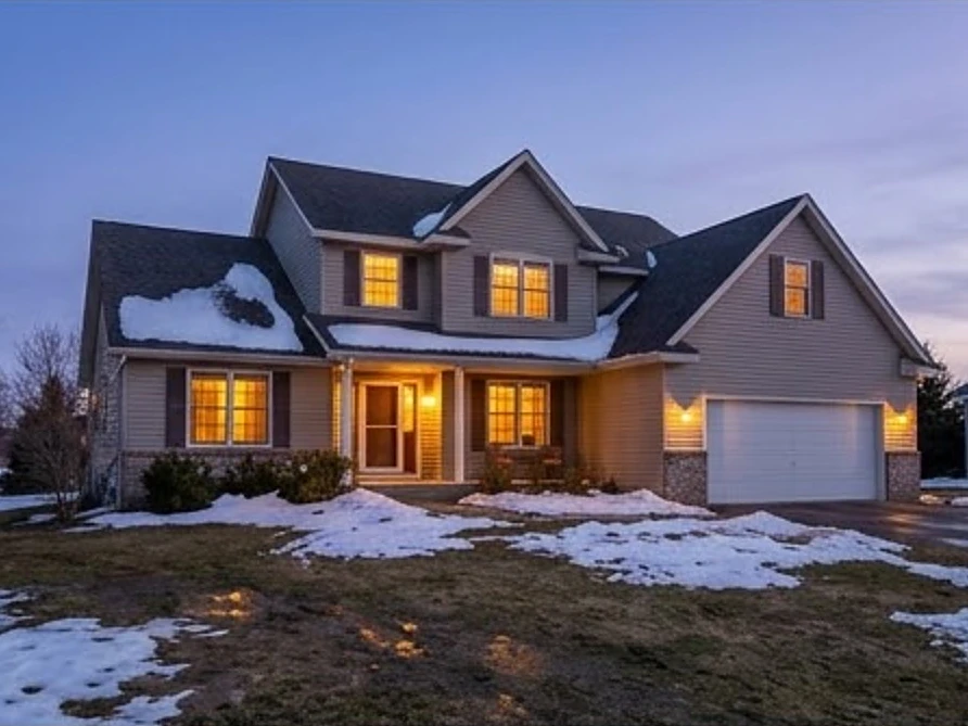 House during spring thaw, dusk with lights on