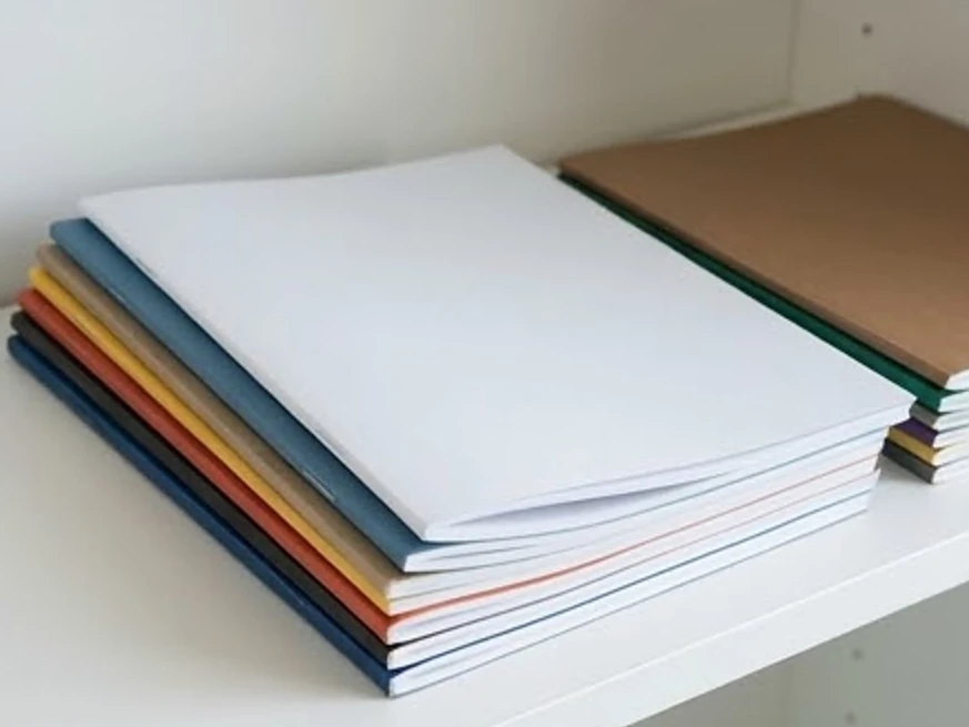 Stack of home guides with blank covers, bright daylight