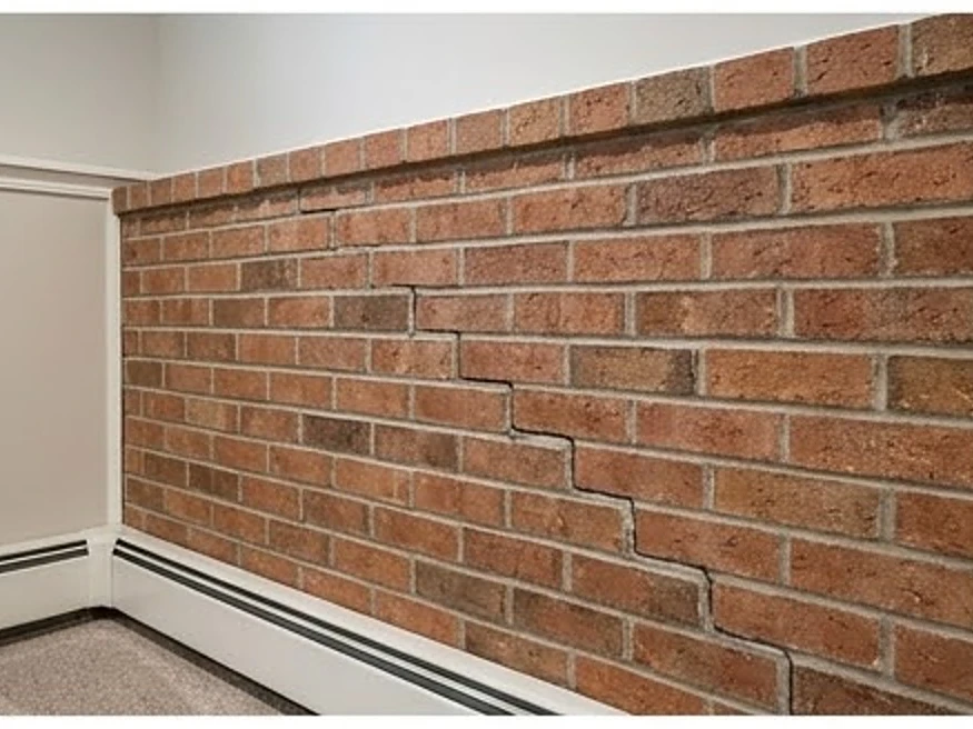 Step crack in a brick foundation, finished-looking basement: foundation inspection in Blaine, MN