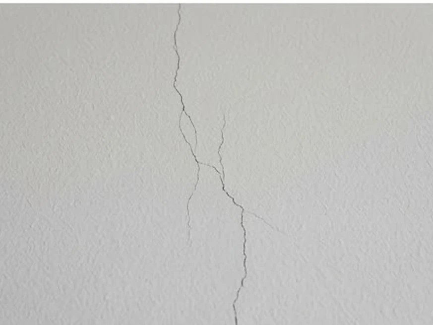Small drywall nail pops on a wall, close-up: 11-month warranty inspection in Mayer, MN