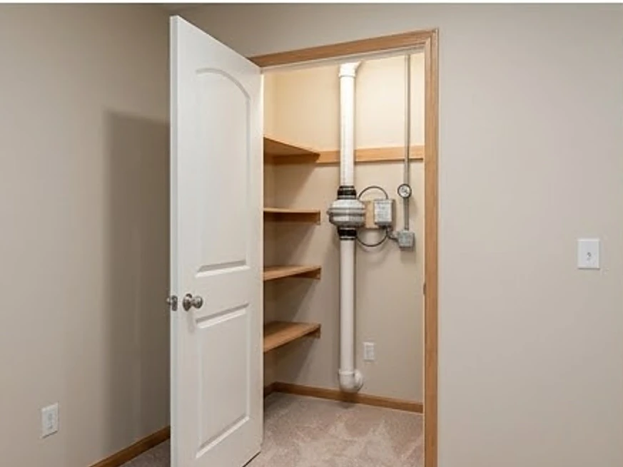 Radon system in a finished basement closet, wider view: radon testing in St. Louis Park, MN