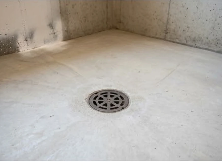 Floor drain in a basement floor, wider view: radon testing in Rosemount, MN