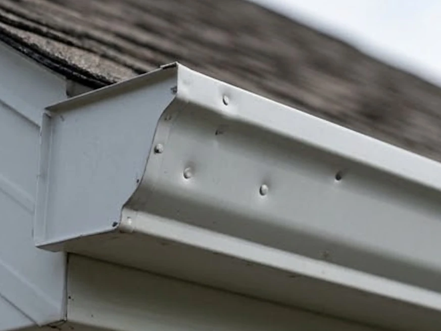 Gutters with hail dents, close-up: roof inspection in North Saint Paul, MN
