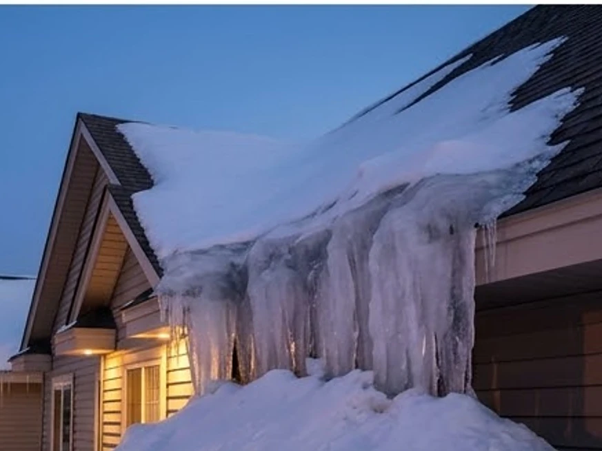 Ice dams along a roofline, dusk: roof inspection in Shoreview, MN
