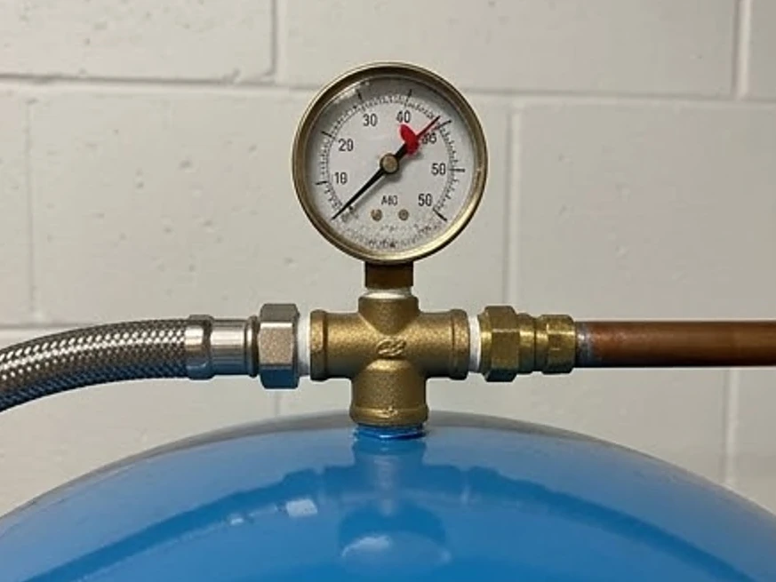 Pressure gauge close-up on a well tank in a newer Minnesota basement: well water testing in Gibbon, MN