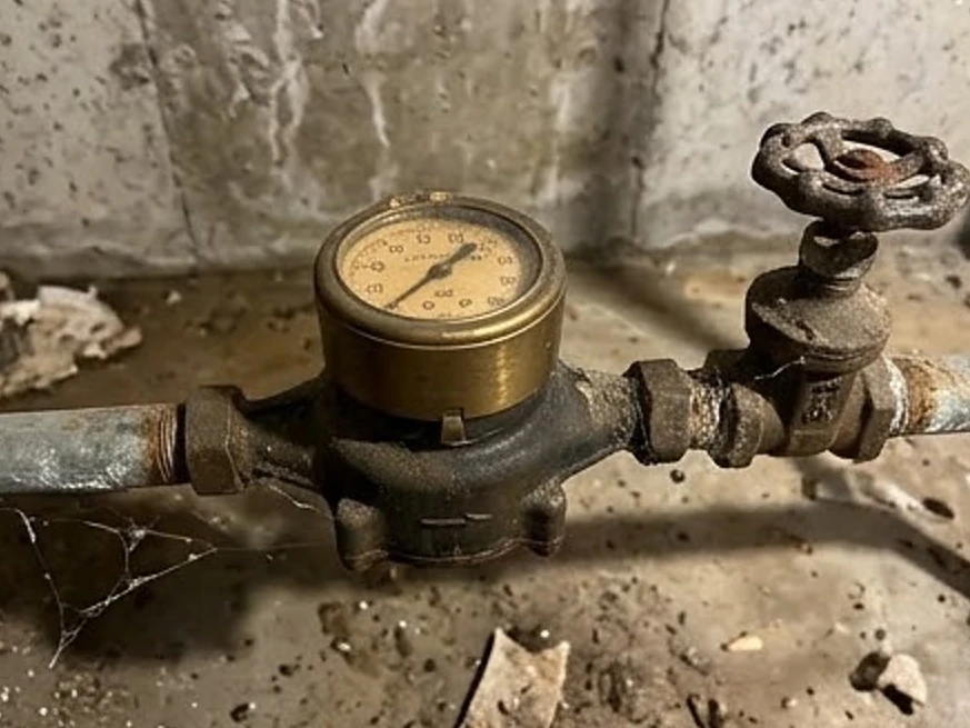 Leland, IA water testing: water meter and shutoff valve in a 1970s unfinished Iowa basement