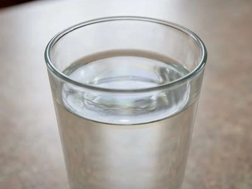 Glass of water with a faint oily sheen on a Iowa kitchen counter close-up (Appanoose County, Iowa)